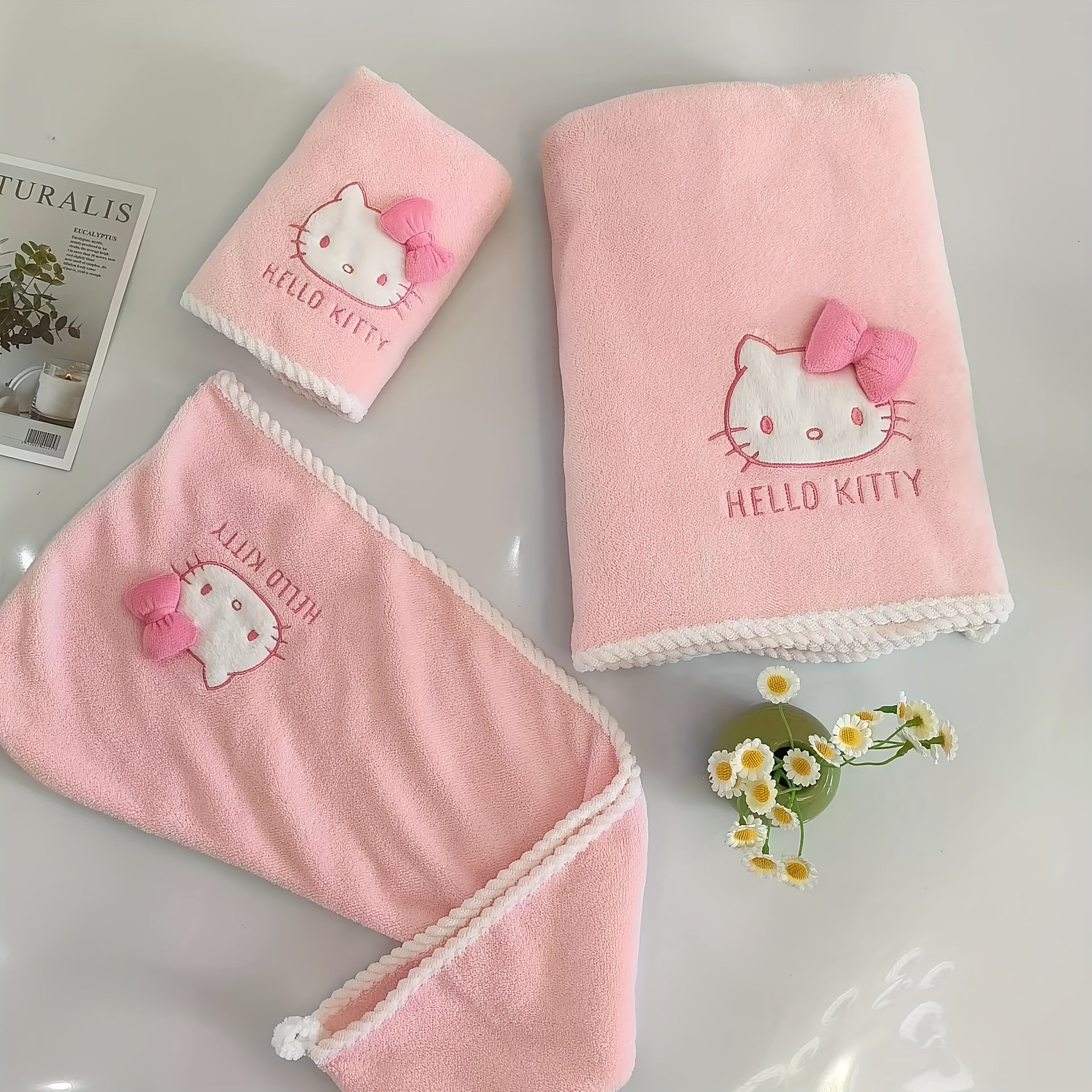 A Set of Three Sanrio Towels Themed Around for Hello Kitty, Including Bath Towels, Face Towels, And a Hair Drying Cap, All Showcasing a Three-Dimensional for Hello Kitty Design