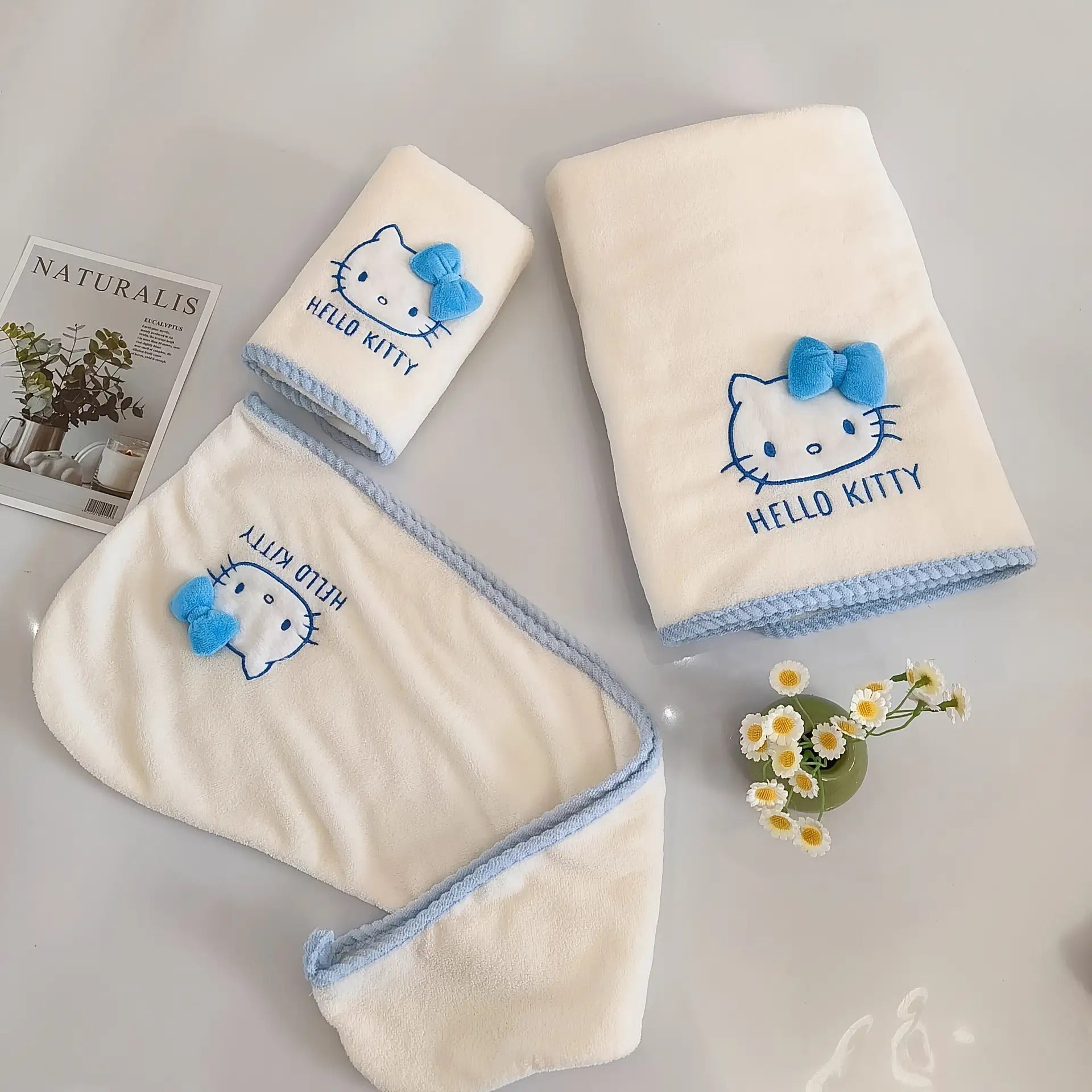 A Set of Three Sanrio Towels Themed Around for Hello Kitty, Including Bath Towels, Face Towels, And a Hair Drying Cap, All Showcasing a Three-Dimensional for Hello Kitty Design